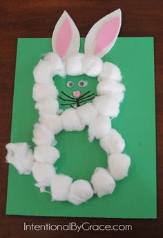 an easter bunny made out of toilet paper on top of a green sheet of paper