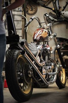 a motorcycle parked inside of a garage next to a person