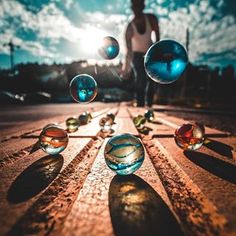 a person standing on the side of a road surrounded by soap bubbles