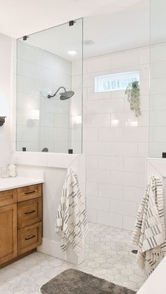 a bathroom with white tile and wooden cabinets