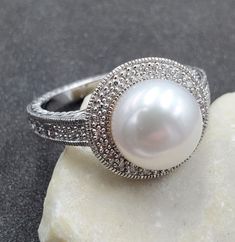 Lovely, QVC Affinity Diamonds, 10mm Pearl and White Diamond 925 Sterling Silver Halo Ring. This beautiful ring is sure to receive many compliments! SOLID925 STERLING SILVER, FULLY TESTED, NOT PLATED OR FILLED. Ring Size: 10.25 Width: 14mm - 2.5mm Gemstone: Pearl / Diamonds Weight: 6.2 Grams Hallmarked: EA / 925 / China We gladly combine shipping! Everything is packed with care to make sure it arrives safely. We only sell authentic items. If it is a name brand item, we guarantee it to be authenti Pearl Ring With Halo Design For Anniversary, Round Halo Design Pearl Anniversary Ring, Round Pearl Ring With Halo For Anniversary, Round Pearl Ring With Halo Design For Anniversary, Classic Pearl Ring With Halo Setting Gift, Anniversary Sterling Silver Pearl Ring With Diamond Accents, Sterling Silver White Halo Ring For Anniversary, White Sterling Silver Halo Ring For Anniversary, Anniversary White Sterling Silver Halo Ring