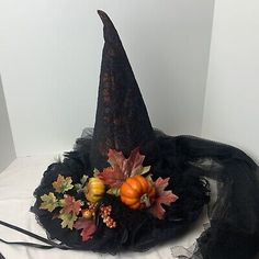 a black hat with leaves, pumpkins and other decorative items on top of it