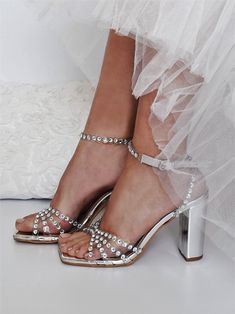 Our sandals have been made in Greece from silver leather and adorned with light-catching crystals that shimmer like a piece of jewelry. They're set on towering 100mm block stilettos. ♥ Colour: Transparent/ Silver ♥ Heel height: 10 cm (3.93 in) ♥ Sizing: Fits true to size, take your normal size ♥ If you need a rush delivery please let us know. ♥ Returns: The item(s) can be returned for refund within 10 days of the order's delivery date. In order for returns to be accepted, all items must be in perfect condition with security tag, original packaging and original invoice. In this case, you shall solely bear the immediate cost of returning the product. ♥ Please add your phone number in your order details. It will be needed for delivery courier. Thank you! We create high quality wedding dresses Silver Ankle Strap Wedding Shoes For Summer, Elegant Sparkling Summer Wedding Shoes, Gala Wedding Shoes With Rhinestones And Ankle Strap, Wedding Shoes With Rhinestones And Ankle Strap For Gala, Embellished Wedding Shoes For Prom With Block Heel, Ankle Strap Wedding Shoes With Rhinestones For Gala, Embellished Block Heel Wedding Shoes For Prom, Bedazzled High Heel Sandals For Weddings, Elegant Wedding Sandals With Bling