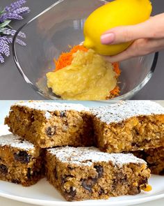 someone is adding powdered sugar to some desserts on a white plate with purple flowers