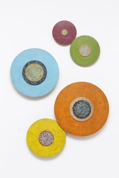 four different colored discs on a white surface