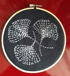 a close up of a black and white embroidery on a red surface