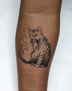 a black and white cat sitting on top of a person's leg