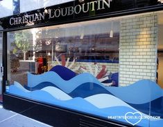 a store front with blue and white waves in the window