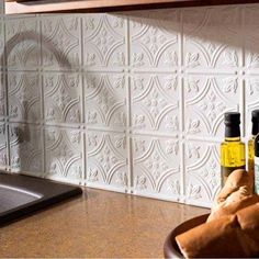 two bottles of olive oil sitting on top of a kitchen counter next to a sink