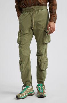 Relaxed-fit cargo pants are equipped with eight pockets, featuring grommets, rivets and snaps throughout for an authentic utilitarian feel. Cut from lightweight cotton poplin, these pants feature a pinched-seam technique before the garment-dye and wash process, revealing subtle variations in color after the pinching is released. 31" inseam; 14" leg opening; 12" front rise; 16" back rise (size Medium) Elastic/drawstring waist Front slant pockets; cargo bellows snap-flap pockets with internal draw Designer Clothing Brands, Cotton Cargo Pants, John Elliott, Cargo Trousers, Drawstring Pants, Cotton Poplin, Flap Pocket, Bottoms Pants, Cargo Pants