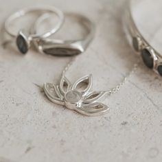 Solidified cremains set in the 5mm circular setting on this stunning and unique .925 Sterling Silver Lotus Flower Cutout Necklace with fixed bails on each side that attach to the chain and an overall size of 24x16mm. The Lotus is a symbol of the beauty that can grow from even the darkest of places, and thus, the love t Sterling Silver Gemstone Necklace For Meditation, Timeless Silver Flower Pendant Jewelry, Delicate Sterling Silver Necklace With Polished Finish, Sterling Silver Birth Flower Fine Jewelry, Elegant Sterling Silver Birth Flower Jewelry, Sterling Silver Nature-inspired Necklace For Anniversary, Spiritual Polished Wedding Necklaces, Sterling Silver White Gold Birth Flower Necklace, Delicate Silver Necklace For Meditation