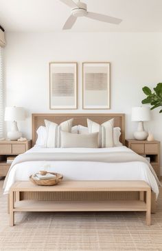 a large bed sitting in a bedroom next to two pictures on the wall above it