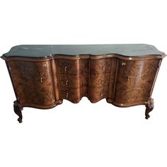 an ornate wooden sideboard with glass top