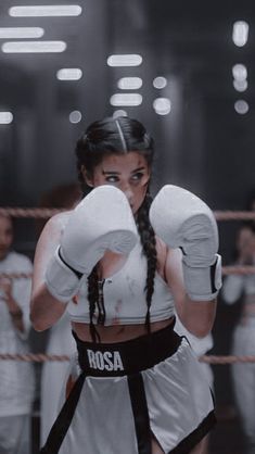 a woman wearing boxing gloves standing in a ring