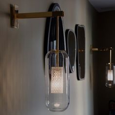 a light fixture hanging from the side of a wall next to a mirror and lights