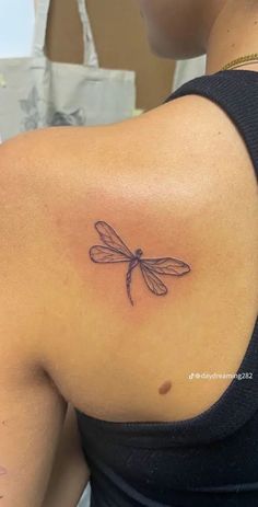 a woman with a dragonfly tattoo on her shoulder