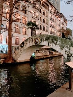 a bridge over a body of water next to a tall building with balconies