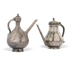 two silver teapots with handles and designs on them