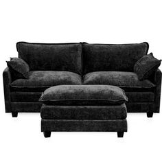 a black couch and footstool sitting next to each other on a white background