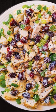 a white plate topped with chicken and cranberry salad