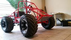 a large red vehicle sitting on top of a tiled floor