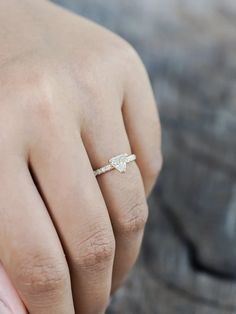 a woman's hand with a diamond ring on top of her finger and the other hand