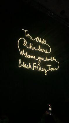 a neon sign that reads to table and behind it is a black background with white writing