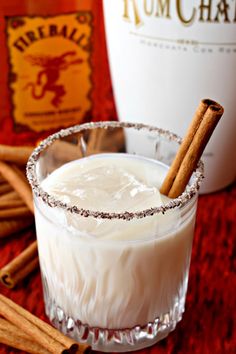 a glass filled with white liquid and cinnamon sticks