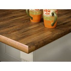 two mugs sitting on top of a wooden counter