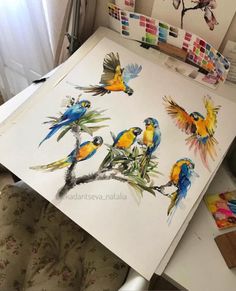 some birds are sitting on top of a white paper with watercolors in the background