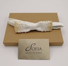 This wonderful bow tie is unique. It is pre-tied and equipped with an adjustable closure. Sofia's bow tie was made from strong cotton and then embroidered with fine golden beads. This gives the bow tie its uniqueness 100% cotton, cream Embroidered with golden beads Pre-tied Adjustable closure approx. 25 cm - 50 cm Dimensions approx. 11 cm x 3 cm Elegant Adjustable Gold Bow, Adjustable White Bow Tie With Decorative Bow, Gold Ribbon Bow For Gifts, Adjustable Ribbon Bow Gift, Elegant Pre-tied Bow For Gift, Adjustable Gold Bow For Party, Adjustable White Bow Tie With Butterfly Knot, White Adjustable Bow With Butterfly Knot, Adjustable Gold Bow Tie As A Gift