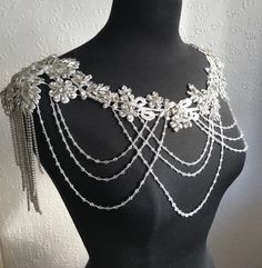 Create a stunning look to your bridal gown with this beautiful rhinestone/crystal shoulder necklace. This will really add a touch of elegance to your attire and you will become a shining star.  A beautiful accessory for a wedding, parties, Valentines Party, Anniversary, and any special occasion. It is simple to to put on and take off. The necklace is handmade to order and is available in silver as shown. The real thing is more beautiful than the pictures.   One of a kind pieces that will make yo Elegant Embellished Rhinestone Necklace For Wedding, Glamorous Embellished Rhinestone Necklace For Wedding, Beaded Crystal Bridal Necklace For Wedding, Wedding Crystal Beaded Rhinestone Necklace, Crystal Bridal Accessories With Rhinestones For Bride, Silver Crystal Body Jewelry For Wedding, Silver Bling Backdrop Necklace For Weddings, Glamorous Silver Backdrop Necklace For Wedding, Crystal Embellished Necklaces For Wedding