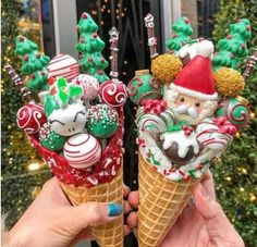 two ice cream cones with christmas decorations and santa clause on top, one holding candy canes