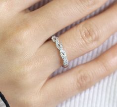 a woman's hand with a diamond ring on her left hand and the middle finger