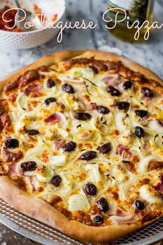 a pizza sitting on top of a pan covered in cheese and olives