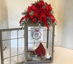 a christmas decoration with candles and a card in a cage that says merry christmas on it