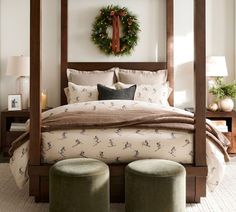 a bedroom with a four poster bed and christmas wreath on the wall