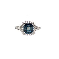 a blue and white diamond ring with diamonds around it's sidestone, set in 18k white gold