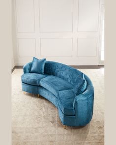 a blue couch sitting on top of a carpeted floor next to a white wall