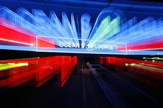 an image of the ocean and lounge sign lit up at night with long exposures