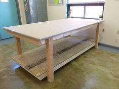 a wooden table sitting on top of a hard wood floor next to a blue door