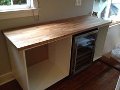 a kitchen counter with an oven built into the top and bottom shelf, in front of a window