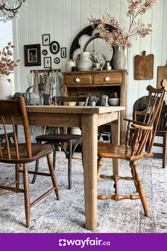 a dining room table with chairs and a mirror on the wall in front of it