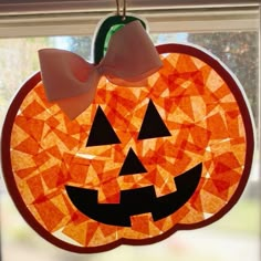 a stained glass pumpkin hanging from a window