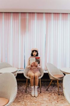 a woman sitting in a chair reading a book