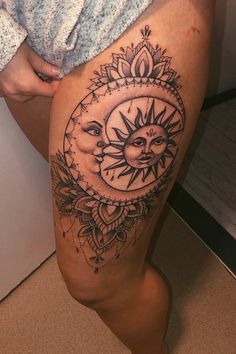 a woman's thigh with a sun and moon tattoo on it