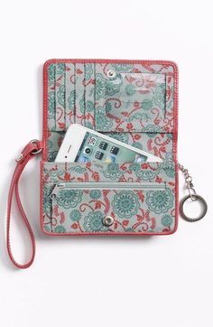 a cell phone and keychain sitting in an open purse on a white surface