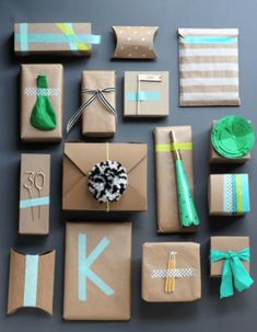 many wrapped presents are laid out on the table with ribbons and paper decorations around them