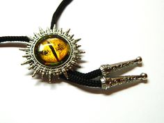 "Draco eye Steampunk Bolo Tie - yellow, green, silver, black. High resolution photo print of Dragon/Tiger eye, crystal glass cabochon (magnifying effect), black cord, silver metal pendants. Bolo Tie size of about 1 1/2\" / 4 cm Draco eye 1\" / 2.5 cm Length of the black cord - 40\" / 100 cm (including metal pendants) Bolo ties: https://www.etsy.com/shop/EmilySteampunk?section_id=14485467 Please take a moment to review my SHOP POLICIES before purchase: https://www.etsy.com/shop/EmilySteampunk/pol Adjustable Gold Jewelry For Halloween, Yellow Novelty Jewelry For Party, Black Novelty Jewelry For Gifts, Adjustable Silver Novelty Jewelry, Gothic Style Adjustable Formal Jewelry, Adjustable Gothic Jewelry For Formal Occasions, Themed Black Jewelry As Gift, Themed Black Jewelry Gift, Adjustable Black Costume Jewelry