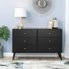 a black dresser with two lamps and a mirror on the wall in a blue room